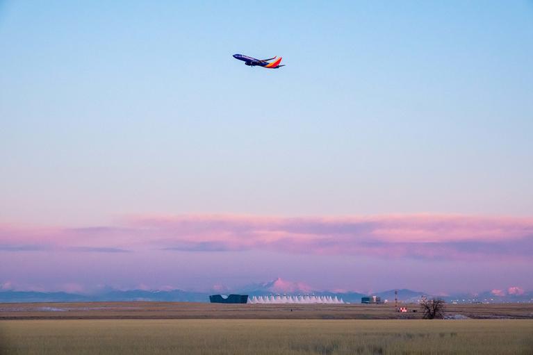 A plane flying over Denver International Airport